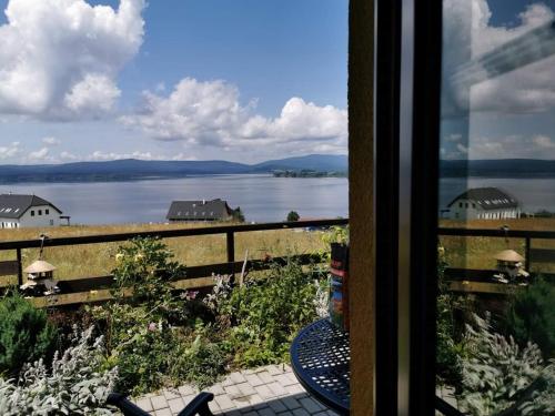 a view of a lake from a window at Apartmán s terasou a výhledem na jezero Lipno in Kovářov