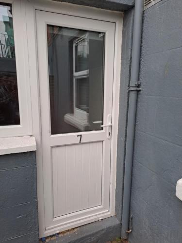 eine weiße Tür an der Seite eines Gebäudes in der Unterkunft Spacious Studio-Dublin 3 in Dublin