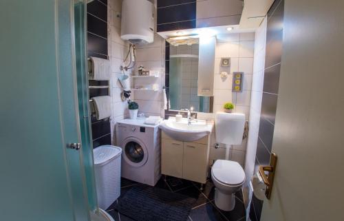 a bathroom with a toilet sink and a washing machine at Luxe Living in Mostar in Mostar
