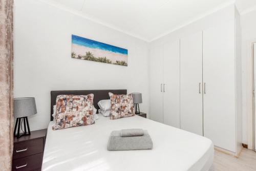 a white bedroom with a white bed and white cabinets at V&S Apartments - Executive Suite in Fourways, Johannesburg in Fourways