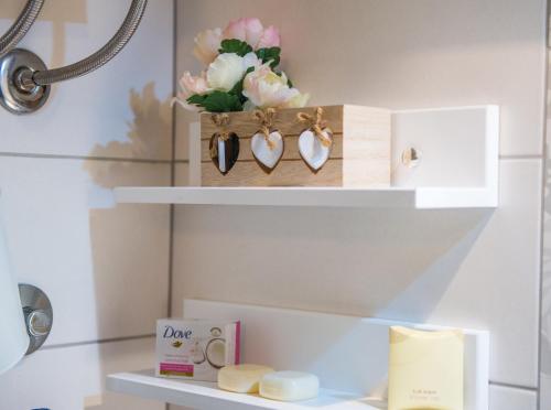 a shelf with two hearts and a vase of flowers at Luxe Living in Mostar in Mostar