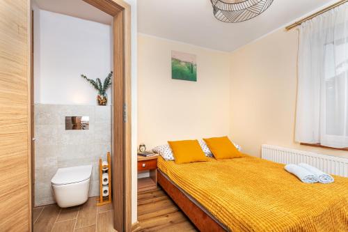 a bedroom with a bed and a toilet in it at KEJB Chałupy in Chałupy