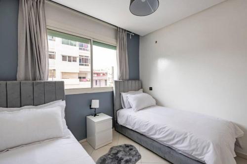 sypialnia z 2 łóżkami i oknem w obiekcie TT Holidays-Rabat City Center w mieście Rabat