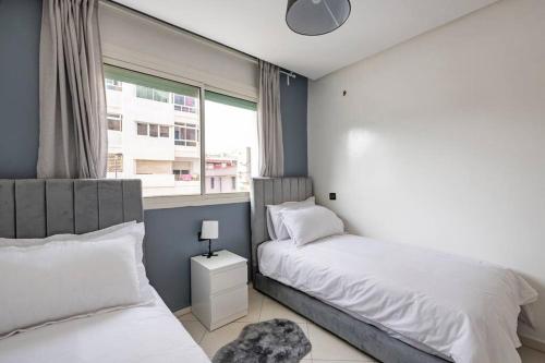 a bedroom with two beds and a window at TT Holidays-Rabat City Center in Rabat