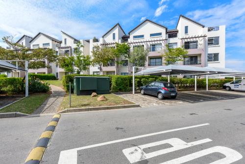 a parking lot in front of a large white building at V&S Apartments - Executive Suite in Fourways, Johannesburg in Fourways