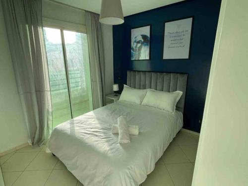 a bedroom with a white bed with a blue wall at TT Holidays-Rabat City Center in Rabat