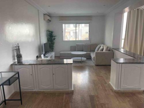 a white living room with a couch and a table at TT Holidays-Rabat City Center in Rabat