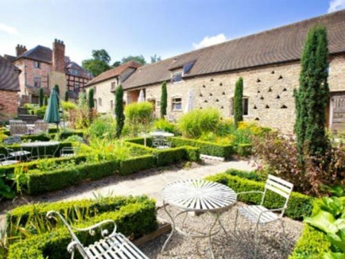 a garden with chairs and tables and a building at Old Downton Lodge in Downton