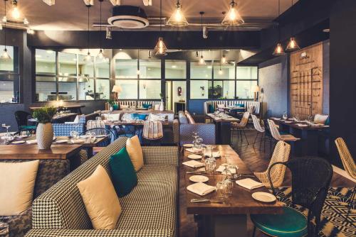a restaurant with couches and tables and chairs at Paradis Plage Surf Yoga & Spa in Taghazout