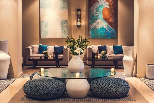 a living room with a table with a vase on it at Paradis Plage Surf Yoga & Spa in Taghazout