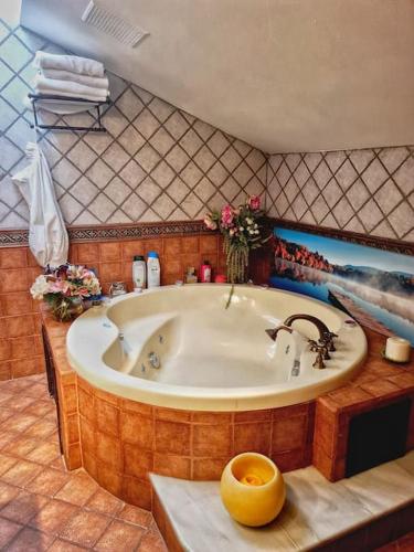 a bathroom with a large tub with a painting on the wall at Atico 3 dormitorios Ron Manuel Marbella Centro in Marbella
