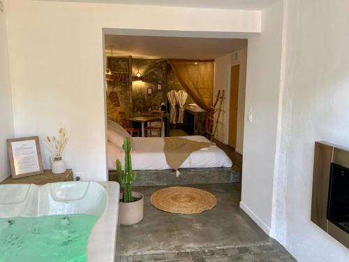 uma casa de banho com uma banheira, uma cama e uma televisão em o5sens em Agde