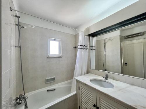 a bathroom with a sink and a tub and a mirror at Albufeira Balaia Golf Vilage 2 With Pool by Homing in Albufeira