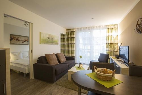 ein Wohnzimmer mit einem Sofa und einem Tisch in der Unterkunft Residenz am Balmer See - BS 12 mit Wellnessbereich in Balm