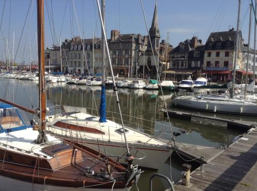 a sail boat docked in a marina with other boats at chambre d'hotes le nid du phare avec jacuzzi in Honfleur