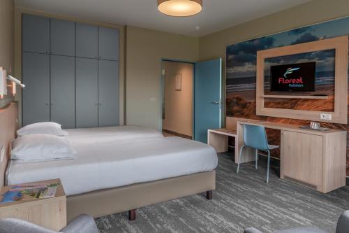 ブランケンベルヘにあるフローラル ブランケンベルグのベッドとデスクが備わるホテルルームです。