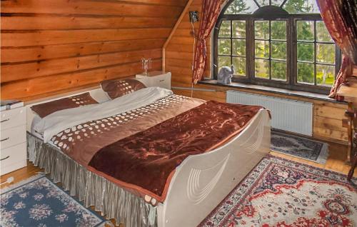 um quarto com uma cama grande num quarto com paredes de madeira em Awesome Home In Lukowo With House A Panoramic View 