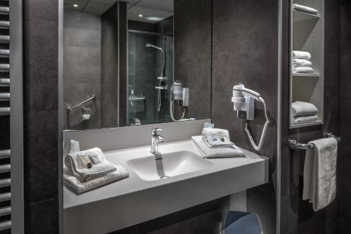 een badkamer met een wastafel en een spiegel bij Floreal Blankenberge in Blankenberge