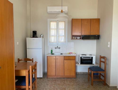 a kitchen with a white refrigerator and a table at Kyklades in Agios Ioannis