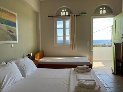 a bedroom with two beds and a view of the ocean at Kyklades in Agios Ioannis