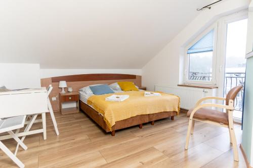 a bedroom with a bed and a desk and a window at KEJB Chałupy in Chałupy