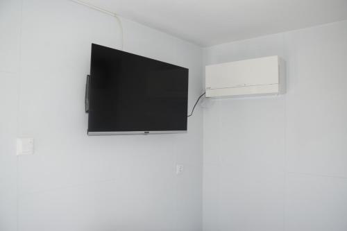 TV de pantalla plana colgada de una pared en Tiny House in ruhiger Lage, en Maria Laah