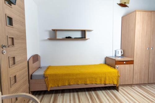 a bedroom with a bed with a yellow blanket at KEJB Chałupy in Chałupy