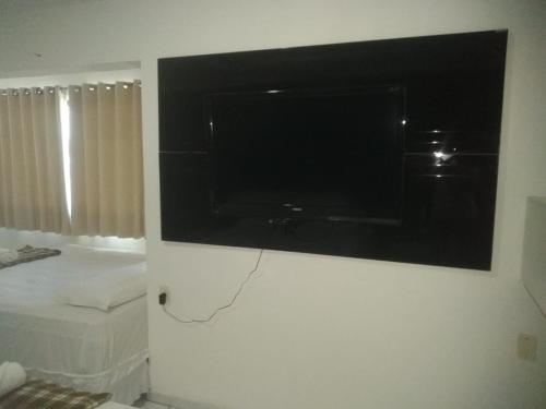 telewizor z płaskim ekranem wiszący na ścianie w pokoju w obiekcie Lax Hotel acesso através de escadas w mieście Campina Grande