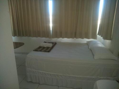 a white bed in a room with a window at Lax Hotel acesso através de escadas in Campina Grande