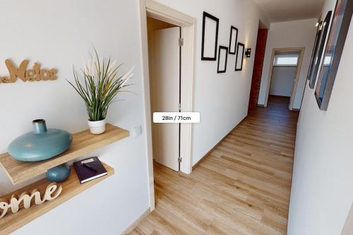 a hallway with white walls and wooden floors at Casa dos Netos in São Bartolomeu de Messines