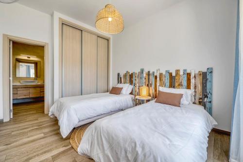 a bedroom with two beds and a mirror at Casa dos Netos in São Bartolomeu de Messines
