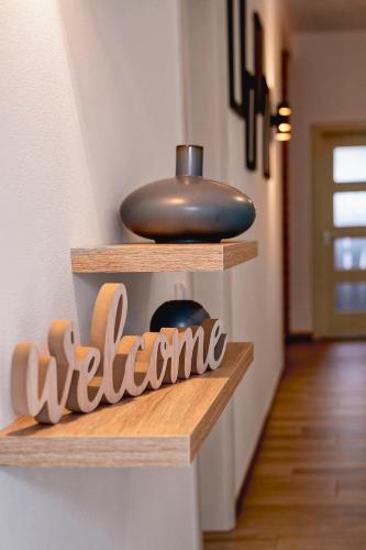 a wooden shelf with a welcome sign on it at Casa dos Netos in São Bartolomeu de Messines