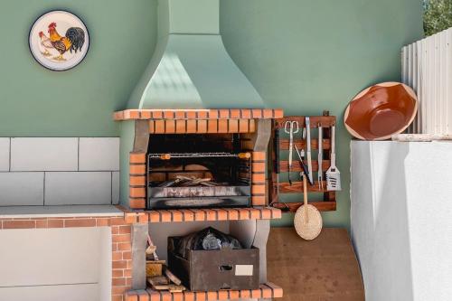 a toy kitchen with a brick oven in a room at Casa dos Netos in São Bartolomeu de Messines