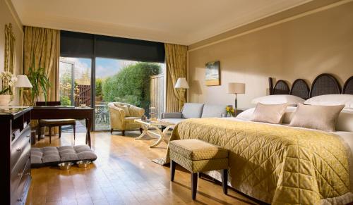a hotel room with a bed and a desk and a room at Castlemartyr Resort Hotel in Castlemartyr