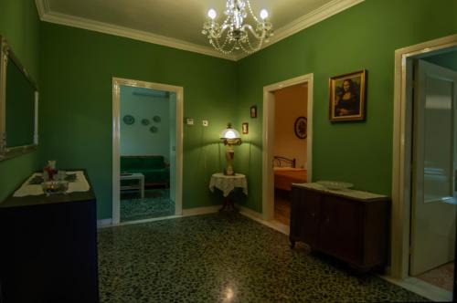 a green bathroom with a sink and a mirror at SkyView Meteora in Kalabaka