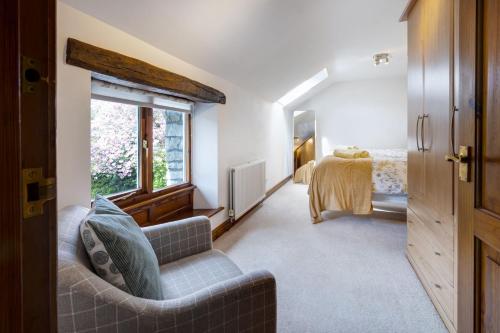 a bedroom with a couch and a bed and a window at Manor Farm Barn Cottage in Burton