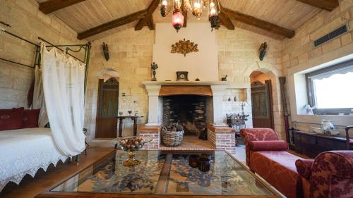 Luxury Villa Allure في Dhafnés: غرفة معيشة مع سرير ومدفأة