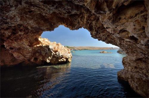 a view of the water from inside a cave at Red Village Limnos in Moúdhros