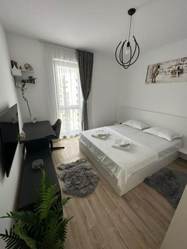 - une chambre blanche avec un lit et une fenêtre dans l'établissement Citta luxury apartment 75, à Bucarest