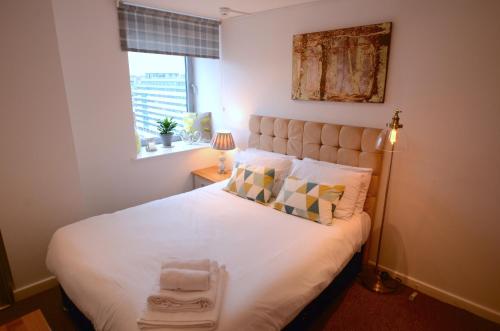 sypialnia z dużym białym łóżkiem i oknem w obiekcie Cranbrook House Apartments - Near Ice Arena w Nottingham