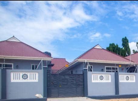 a couple of houses with a fence in front of them at Romantic, Stunning & Authentic Ensuited Master Bedroom in Dar es Salaam