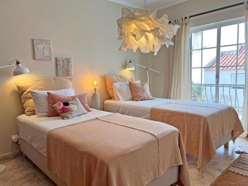 a bedroom with two beds and a large window at Casa Miobelle - Tavira in Tavira