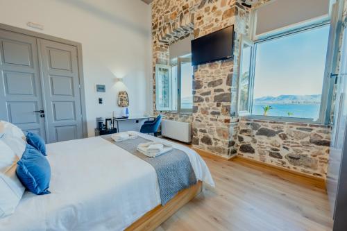 a bedroom with a bed and a large window at Impero Nafplio Hotel & Suites in Nafplio