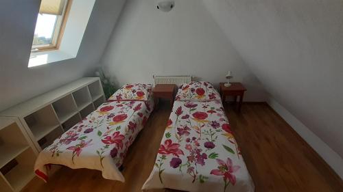 a bedroom with two beds with floral sheets at Pensjonat Belona in Dziwnów
