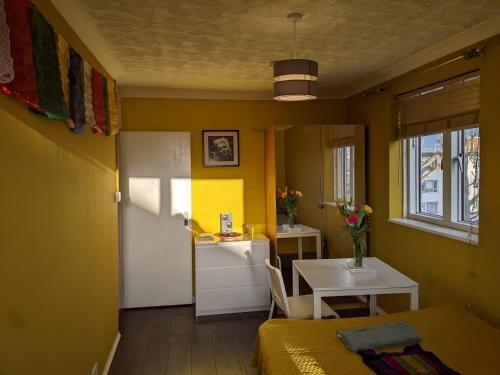 a room with a bed and a table and a kitchen at Creatives' House in London