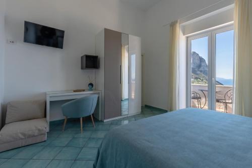 una camera con letto, scrivania e finestra di Albergo La Prora a Capri