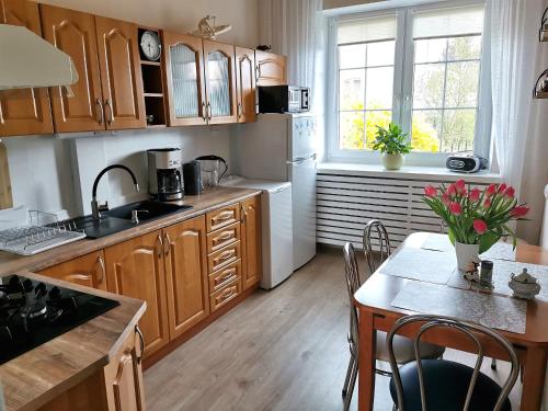 una cocina con armarios de madera y una mesa con mesa. en Apartament z widokiem na jezioro Ukiel en Olsztyn