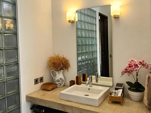 ein Bad mit einem Waschbecken und einem Spiegel in der Unterkunft Villa Kali in Seminyak