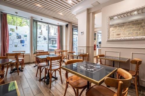 un restaurant avec des tables et des chaises dans une salle dans l'établissement District Republique, à Paris