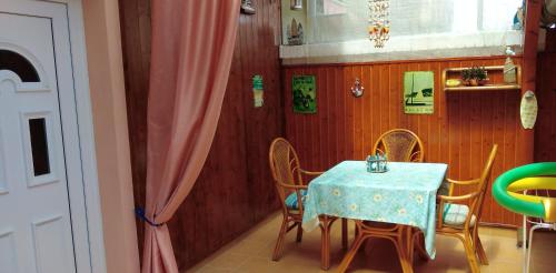 a dining room with a table with chairs and a blue table cloth at Maxim Ház in Hévíz